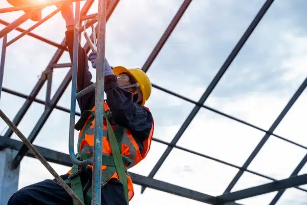 Construction worker wearing safety harness on scaffolding

