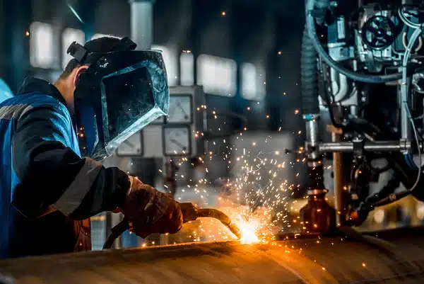 Welder working in a busy construction site in Fresno