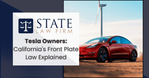 Red Tesla parked near a wind turbine