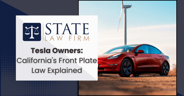 Red Tesla parked near a wind turbine