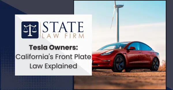 Red Tesla parked near a wind turbine